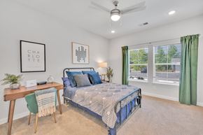 Charlotte apartment for rent - a bedroom with a bed and two windows at spire luxury apartments