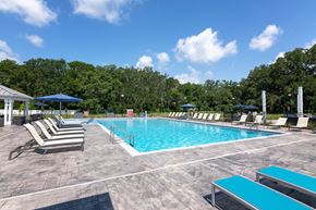 Newberry apartment for rent - A pool surrounded by trees and chairs.