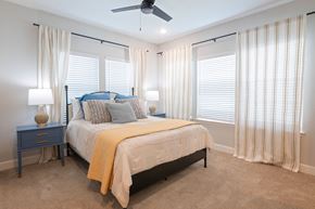 Newberry apartment for rent - A bedroom with a bed, nightstand, and window with curtains.