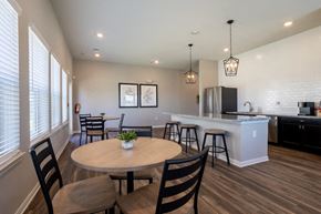 Beaumont apartment for rent - Clubhouse kitchen with tables, chairs, and appliances in the background