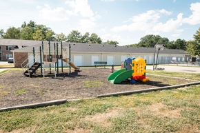 Newburgh apartment for rent - A playground with a yellow and green slide and a brown and green climbing structure.