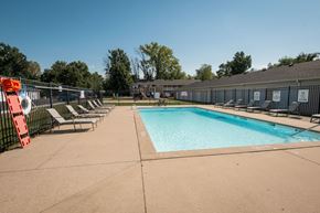 Newburgh apartment for rent - A large outdoor swimming pool surrounded by a fence and lounge chairs.