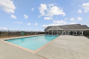 Del Valle apartment for rent - A large outdoor swimming pool with a black fence surrounding it.