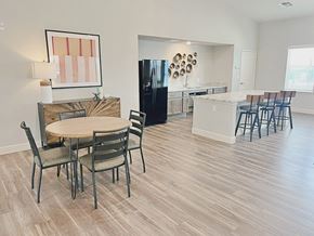 Austin apartment for rent - A kitchen with a table and chairs in the foreground and a refrigerator in the background.