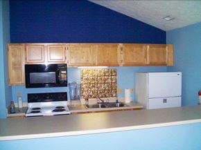 Liberty apartment for rent - Clubhouse kitchen with a stove top oven next to a refrigerator at Patriot Pointe Apartments in Liberty, IN
