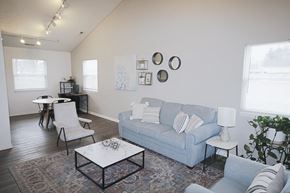 Connersville apartment for rent - A living room with a blue couch, a white coffee table, and a white chair.