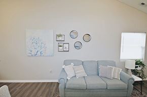 Connersville apartment for rent - A living room with a grey couch and a painting on the wall.