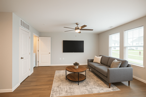Indianapolis apartment for rent - A living room with a grey couch, a coffee table, and a flat screen TV mounted on the wall.