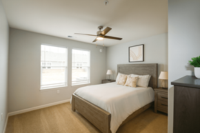 Indianapolis apartment for rent - A bedroom with a bed, nightstand, and a ceiling fan.