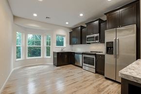 Lindenhurst apartment for rent - an empty kitchen with stainless steel appliances and black cabinets
