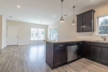 Amityville apartment for rent - the kitchen and living room of a new home with dark cabinets