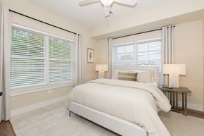 West Babylon apartment for rent - A bedroom with a large bed and a ceiling fan.