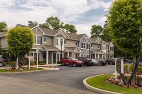 Amityville apartment for rent - a row of houses with cars parked in front of them