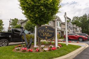 Amityville apartment for rent - a sign for old oliver hills in front of a row of houses