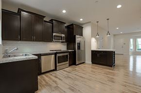Lindenhurst apartment for rent - a large kitchen with black cabinets and stainless steel appliances