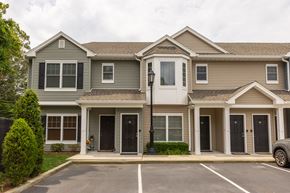 Amityville apartment for rent - a house with a parking lot in front of it