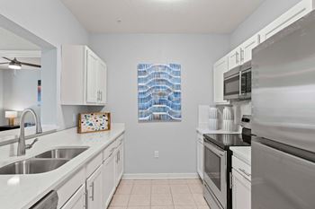 A kitchen with white cabinets and a stainless steel oven.