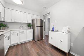 Highland apartment for rent - a kitchen with white cabinets and a stainless steel refrigerator at Hampton in Highland Apartments, Highland, IN, 46322