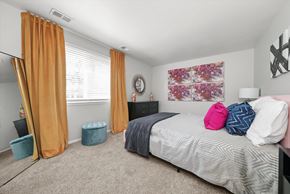 Highland apartment for rent - a bedroom with a bed and a window with orange curtains at Hampton in Highland Apartments, Indiana, 46322