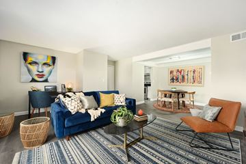 Kansas City apartment for rent - A living room with a blue couch and a painting on the wall.