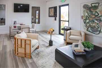 Merrillville apartment for rent - A living room with a black coffee table and a large painting on the wall.