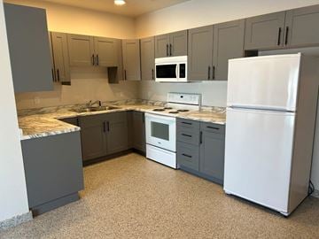 Mitchell apartment for rent - a kitchen with white appliances and gray cabinets