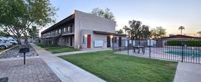 Phoenix apartment for rent - A walkway leading to a pool with a black fence and apartment building
