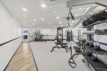 A gym with a variety of equipment including weights and machines.