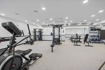 A spacious gym with treadmills, elliptical machines, and weightlifting equipment.