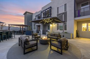 A patio with a fire pit and seating area.
