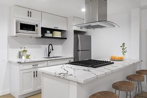 Torrance apartment for rent - A kitchen with a black and white marble countertop and white cabinets.