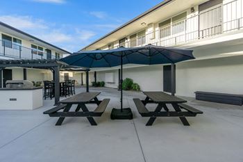 A patio with a table and chairs under an umbrella.