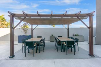 A patio with a table and chairs under a pergola.