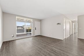Carlsbad apartment for rent - A spacious room with a large window and wooden flooring.