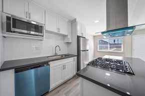 West Covina apartment for rent - a modern kitchen with white cabinets and stainless steel appliances at Wescove Apartments, West Covina, 91790