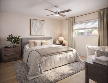 Brea apartment for rent - A bedroom with a large bed, a ceiling fan, and a nightstand with a plant on it.