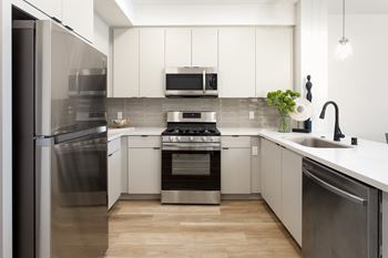 A modern kitchen with stainless steel appliances and white cabinets.