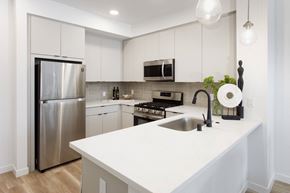 La Mirada apartment for rent - A modern kitchen with a stainless steel refrigerator and a white countertop. at The Reserve La Mirada, La Mirada, California