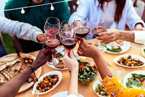 Costa Mesa apartment for rent - A group of people toasting with wine glasses at a dinner table at 325 on Seventeenth Apartments, Costa Mesa, CA