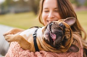 Costa Mesa apartment for rent - A woman is holding a happy dog in her arms at 325 on Seventeenth Apartments, Costa Mesa 92627