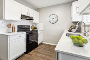 Benbrook apartment for rent - A kitchen with a black oven and white cabinets.