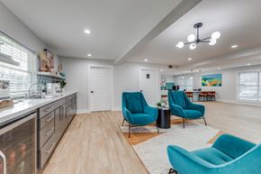 Dallas apartment for rent - A kitchen with a white counter top and blue chairs. at Carisma, Dallas