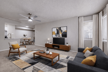 Garland apartment for rent - A living room with a grey couch, a wooden coffee table, and a painting on the wall.