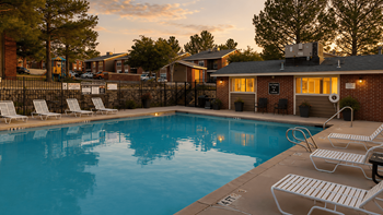 Pool deck with lounge chairs and brick clubhouse