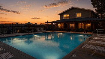 Evening poolside view with illuminated clubhouse building