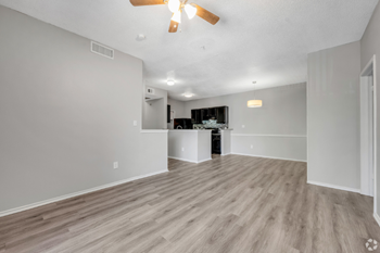 A spacious room with a ceiling fan and lighting fixtures.