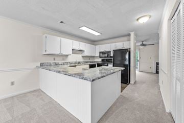 Rocky Mount apartment for rent - a kitchen with white cabinets and a granite counter top