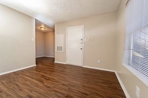 Dallas apartment for rent - an empty living room with wood flooring and a window