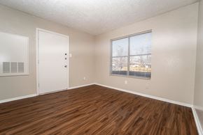Dallas apartment for rent - an empty living room with wood flooring and a window
