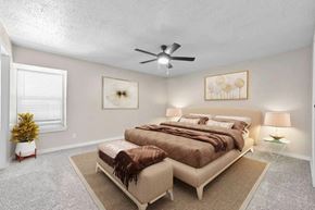 Dallas apartment for rent - A bedroom with a large bed and a ceiling fan.